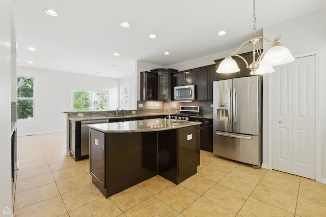652 Grosvenor Ln, Aurora, IL 60504 - kitchen with appliances with stainless steel finishes, light tile patterned floors, an island with sink, glass insert cabinets, and light stone counters
