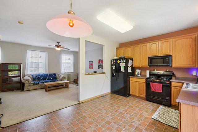 1911 Indian Hill Ln, Aurora, IL 60503 - kitchen with black appliances, light carpet, ceiling fan, open floor plan, and light countertops