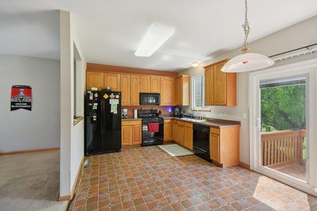 1911 Indian Hill Ln, Aurora, IL 60503 - kitchen featuring black appliances, hanging light fixtures, and light countertops