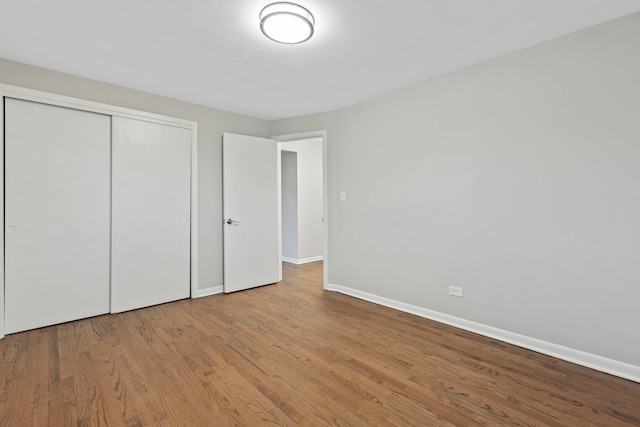 6964 W Diversey Ave Unit 7, Chicago, IL 60707 - unfurnished bedroom featuring baseboards, a closet, and wood finished floors