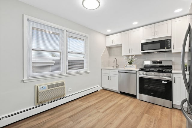 6964 W Diversey Ave Unit 7, Chicago, IL 60707 - kitchen featuring appliances with stainless steel finishes, a sink, light wood-style floors, light countertops, and a baseboard heating unit