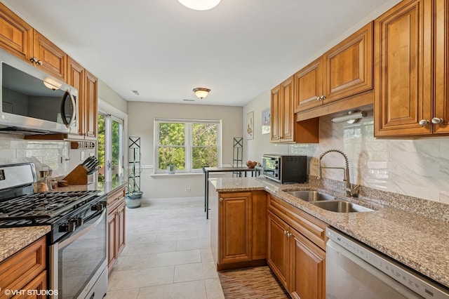 2980 Northampton Dr Unit A2, Rolling Meadows, IL 60008 - kitchen with stainless steel appliances, baseboards, a sink, light stone counters, and tasteful backsplash