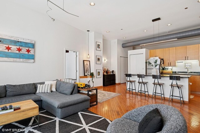 333 W Hubbard St Unit 708, Chicago, IL 60654 - living area with light wood-style flooring, recessed lighting, and a towering ceiling