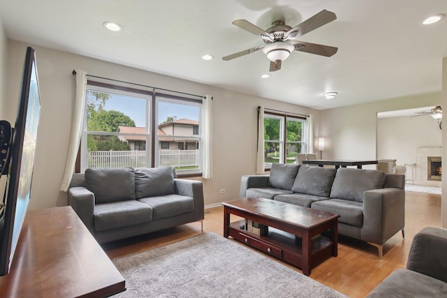 104 S Walnut Ln, Schaumburg, IL 60193 - living room with ceiling fan, recessed lighting, light wood-style flooring, and a warm lit fireplace