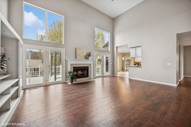 6 Valhalla Ct, Lake In The Hills, IL 60156 - unfurnished living room with hardwood / wood-style floors, a towering ceiling, healthy amount of natural light, and a tiled fireplace