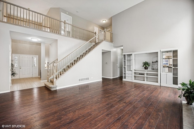 6 Valhalla Ct, Lake In The Hills, IL 60156 - unfurnished living room with a towering ceiling, hardwood / wood-style floors, stairway, and baseboards
