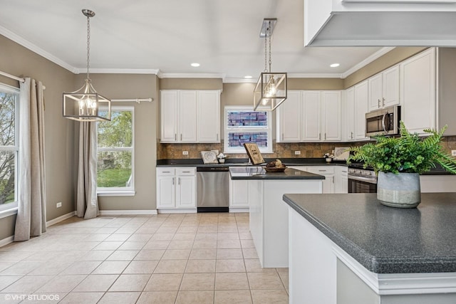 6 Valhalla Ct, Lake In The Hills, IL 60156 - kitchen with appliances with stainless steel finishes, dark countertops, backsplash, light tile patterned floors, and a center island