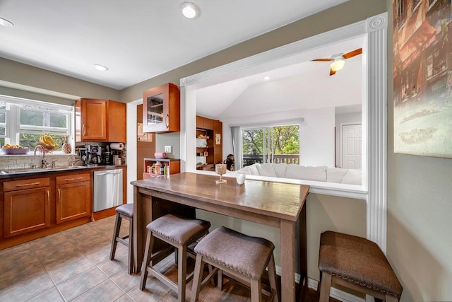 3907 N Harlem Ave Unit 304B, Chicago, IL 60634 - kitchen featuring dishwasher, brown cabinets, a kitchen breakfast bar, a sink, and dark countertops