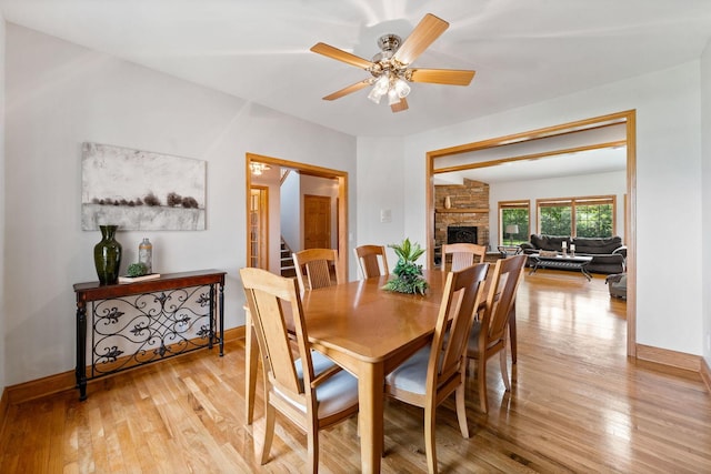 6099 Polo Club Dr, Yorkville, IL 60560 - dining room featuring light wood-style floors, a fireplace, and ceiling fan