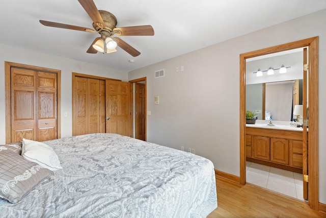 6099 Polo Club Dr, Yorkville, IL 60560 - bedroom featuring multiple closets, connected bathroom, light wood-type flooring, and a ceiling fan