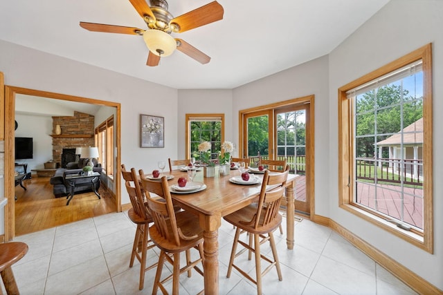 6099 Polo Club Dr, Yorkville, IL 60560 - dining area with healthy amount of natural light, light tile patterned floors, a stone fireplace, and ceiling fan