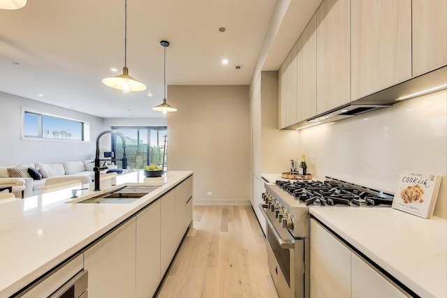 613 N Ogden Ave Unit 4W, Chicago, IL 60642 - kitchen with high end stainless steel range oven, light countertops, light wood-style floors, open floor plan, and modern cabinets