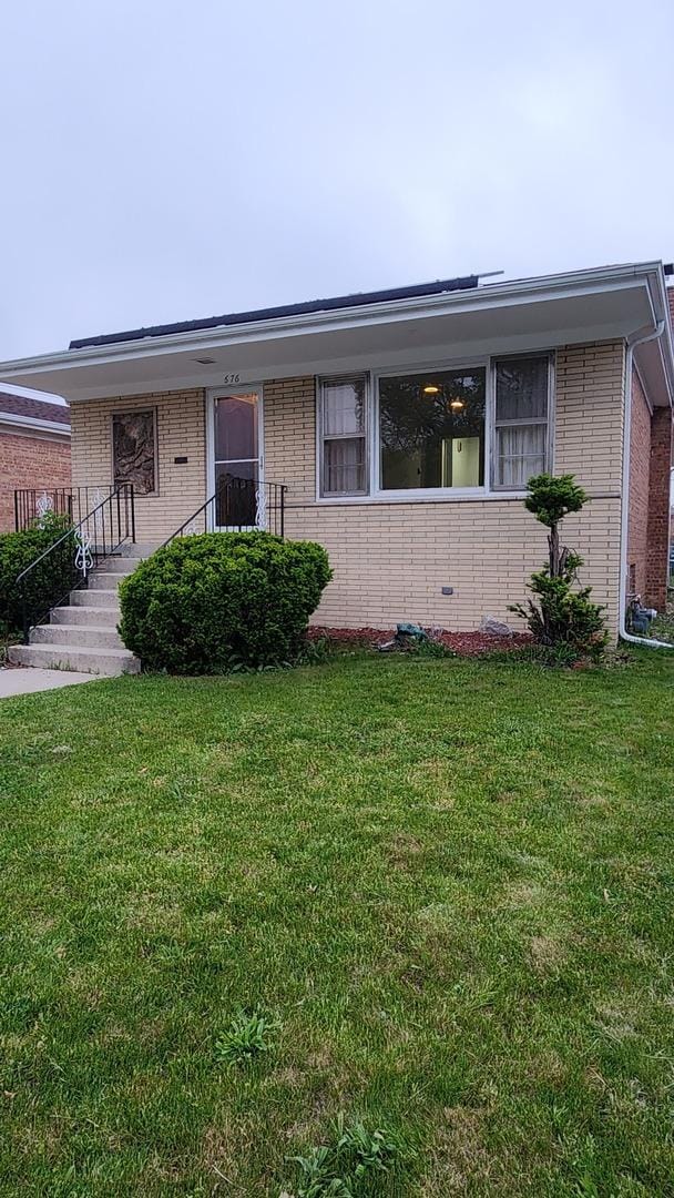 ranch-style house with brick siding and a front yard