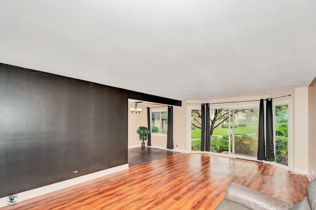 3030 Roberts Dr Unit 4, Woodridge, IL 60517 - unfurnished living room with wood finished floors, a chandelier, and baseboards