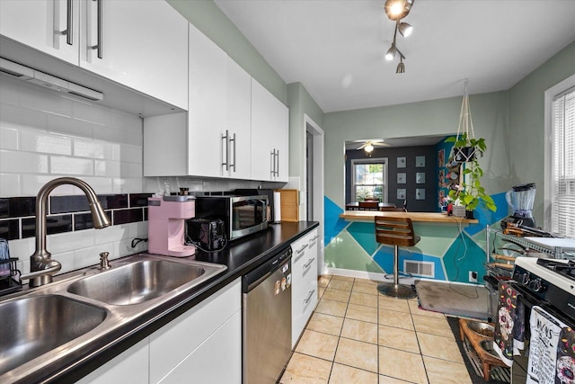 475 S Edison Ave, Elgin, IL 60123 - kitchen with stainless steel appliances, backsplash, white cabinets, light tile patterned flooring, and ceiling fan