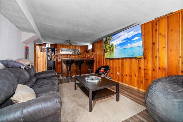 475 S Edison Ave, Elgin, IL 60123 - living room featuring wooden walls, wood finished floors, a textured ceiling, ceiling fan, and a dry bar