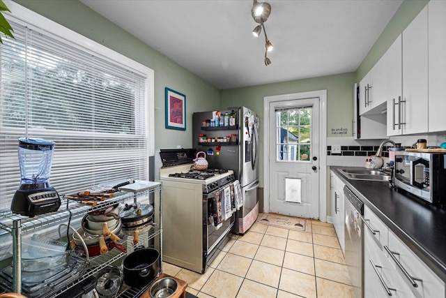 475 S Edison Ave, Elgin, IL 60123 - kitchen featuring appliances with stainless steel finishes, light tile patterned floors, white cabinetry, dark countertops, and tasteful backsplash
