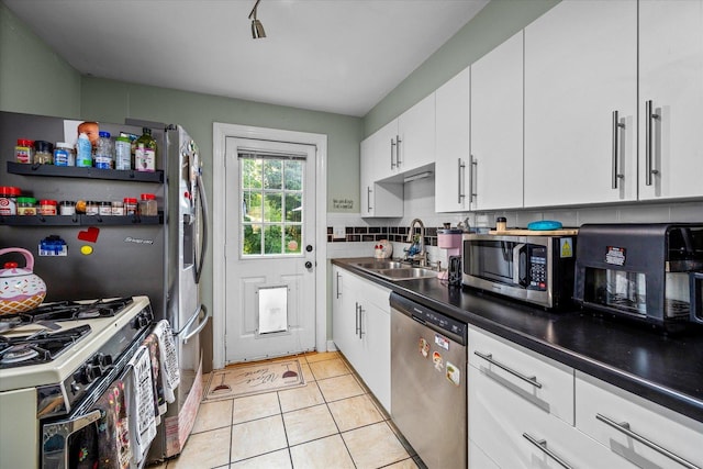 475 S Edison Ave, Elgin, IL 60123 - kitchen with stainless steel appliances, white cabinetry, light tile patterned floors, dark countertops, and decorative backsplash