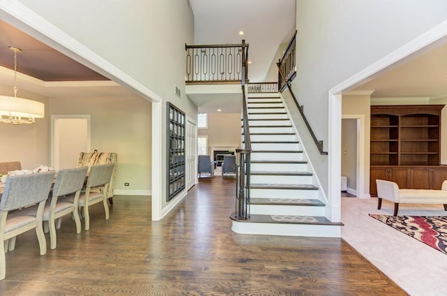 6205 Brookridge Dr, Plainfield, IL 60586 - stairway with wood finished floors, a chandelier, baseboards, ornamental molding, and a fireplace