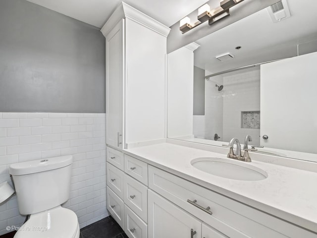 1632 S Indiana Ave Unit 304, Chicago, IL 60616 - bathroom featuring toilet, vanity, tile walls, a shower, and a wainscoted wall