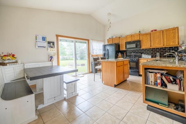 608 Cherry Tree Ln, Genoa, IL 60135 - kitchen with black appliances, a center island, light tile patterned floors, decorative backsplash, and a sink