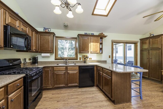 33061 N Rolling Hills Rd, Grayslake, IL 60030 - kitchen featuring black appliances, a sink, a breakfast bar, a peninsula, and plenty of natural light
