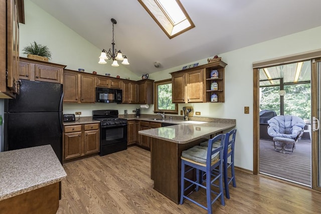 33061 N Rolling Hills Rd, Grayslake, IL 60030 - kitchen with black appliances, a sink, a chandelier, light wood-type flooring, and a peninsula