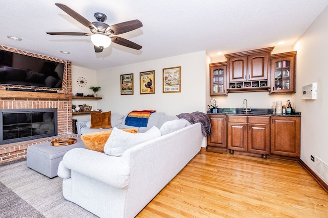 181 N Meadowlark Dr, Hawthorn Woods, IL 60047 - living area with wet bar, light wood finished floors, a fireplace, ceiling fan, and recessed lighting