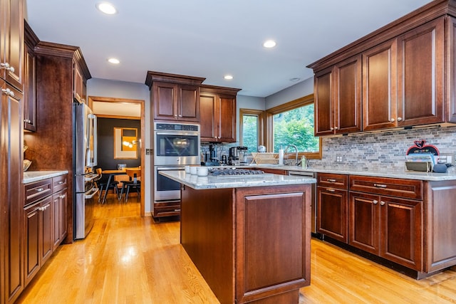 181 N Meadowlark Dr, Hawthorn Woods, IL 60047 - kitchen with appliances with stainless steel finishes, light wood finished floors, decorative backsplash, a center island, and light stone counters