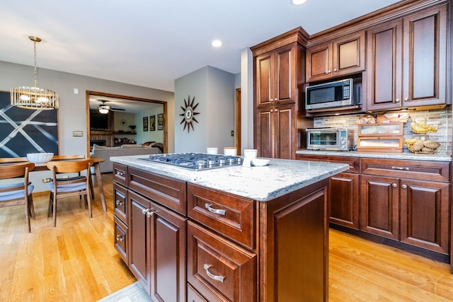 181 N Meadowlark Dr, Hawthorn Woods, IL 60047 - kitchen with stainless steel appliances, light wood-style flooring, a center island, hanging light fixtures, and light stone counters
