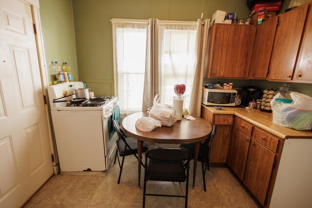 341 S 5th Ave, Kankakee, IL 60901 - kitchen with white gas stove, stainless steel microwave, light countertops, and brown cabinets