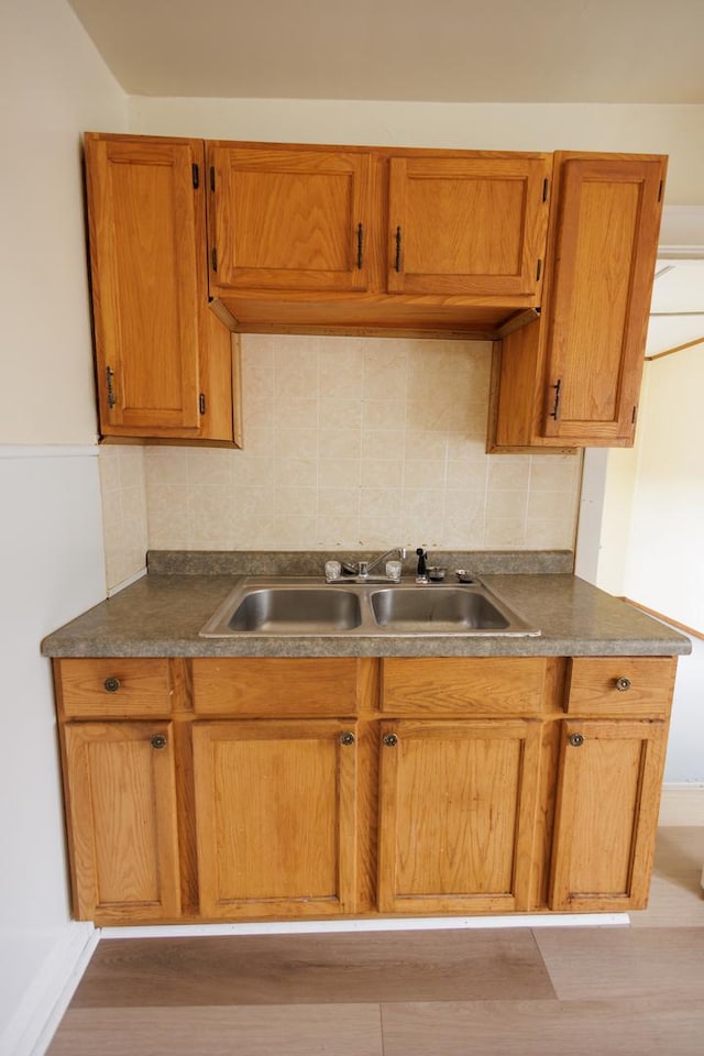 341 S 5th Ave, Kankakee, IL 60901 - kitchen with a sink, tasteful backsplash, brown cabinetry, and dark countertops