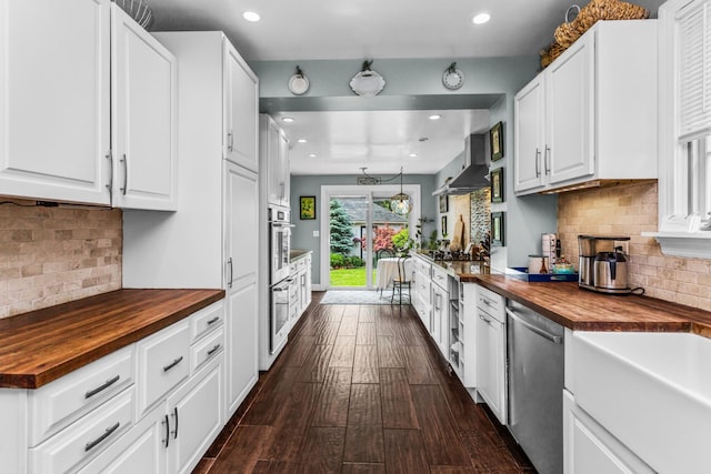 1414 Lincoln St, Evanston, IL 60201 - kitchen featuring butcher block countertops, stainless steel dishwasher, wall chimney range hood, recessed lighting, and decorative backsplash