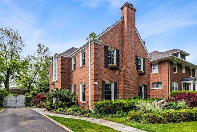 1414 Lincoln St, Evanston, IL 60201 - view of side of home with a chimney, a gate, and brick siding
