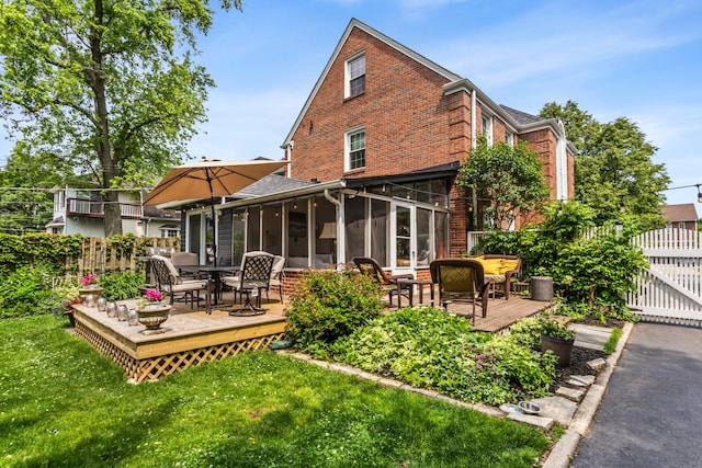 1414 Lincoln St, Evanston, IL 60201 - rear view of house with a wooden deck, brick siding, outdoor dining space, and a sunroom
