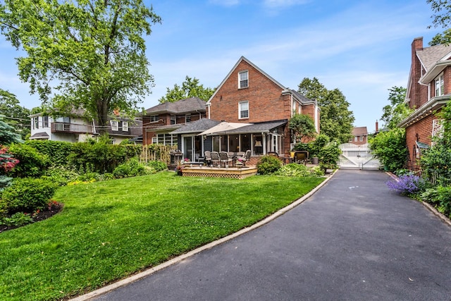1414 Lincoln St, Evanston, IL 60201 - back of property with a wooden deck, a yard, brick siding, and a garage