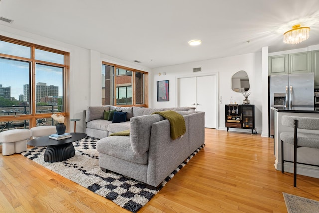 1444 N Orleans St Unit 6C, Chicago, IL 60610 - living room with light wood-style floors, a chandelier, and a view of city