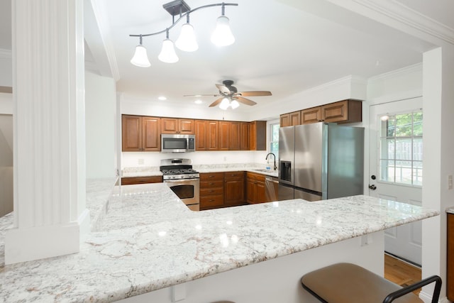 0N244 Peter Rd, Winfield, IL 60190 - kitchen with appliances with stainless steel finishes, brown cabinets, a breakfast bar, light stone counters, and ornamental molding