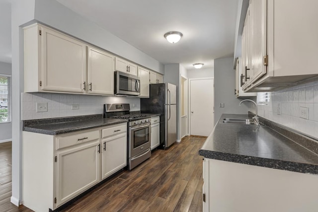 1 W Pheasant Trl, Lake In The Hills, IL 60156 - kitchen featuring appliances with stainless steel finishes, a sink, dark wood-type flooring, and decorative backsplash
