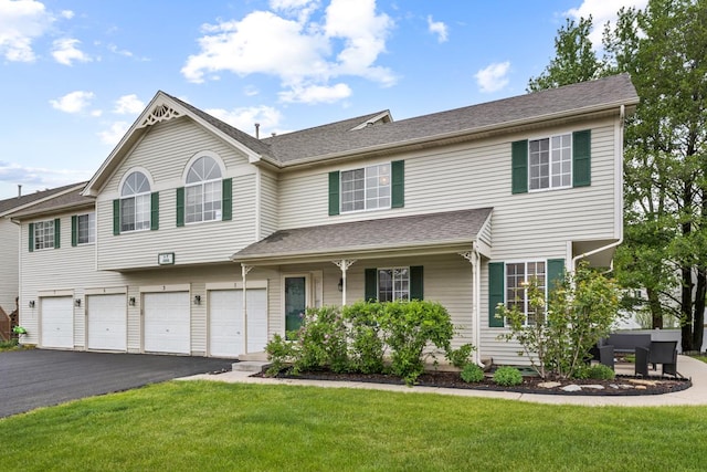 1 W Pheasant Trl, Lake In The Hills, IL 60156 - view of property featuring driveway, a front yard, an attached garage, covered porch, and a shingled roof