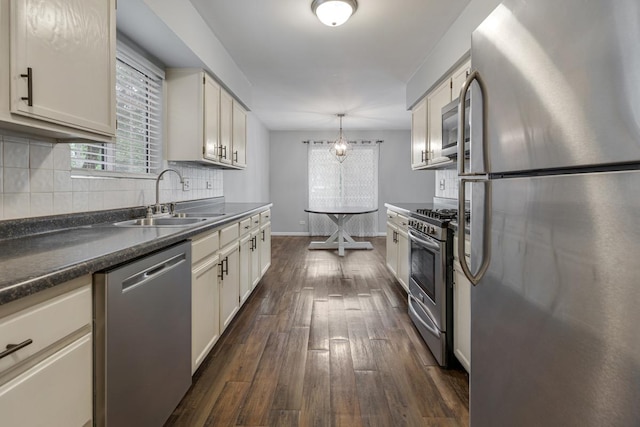 1 W Pheasant Trl, Lake In The Hills, IL 60156 - kitchen featuring appliances with stainless steel finishes, a sink, dark countertops, dark wood-type flooring, and decorative backsplash