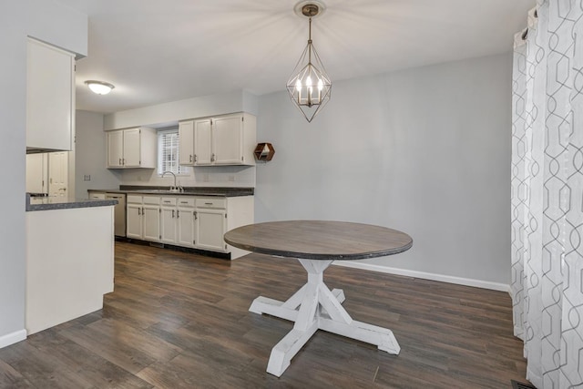 1 W Pheasant Trl, Lake In The Hills, IL 60156 - kitchen with dark countertops, a sink, baseboards, dark wood-style floors, and white cabinetry