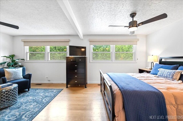 636 Cambridge Dr, Schaumburg, IL 60193 - bedroom with multiple windows, a textured ceiling, wood finished floors, ceiling fan, and beamed ceiling