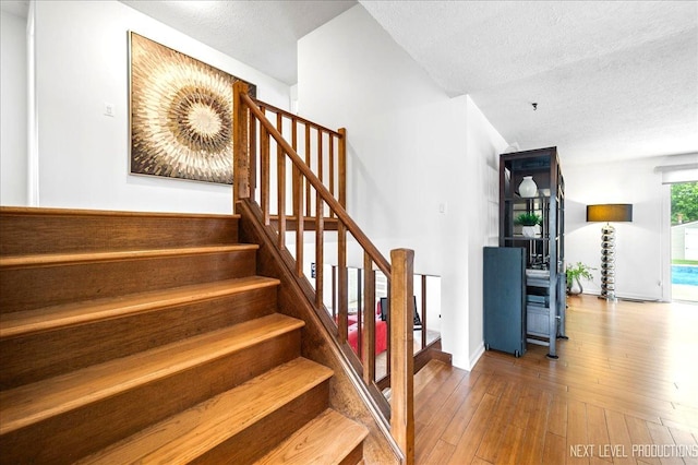 636 Cambridge Dr, Schaumburg, IL 60193 - stairway featuring a textured ceiling and hardwood / wood-style floors