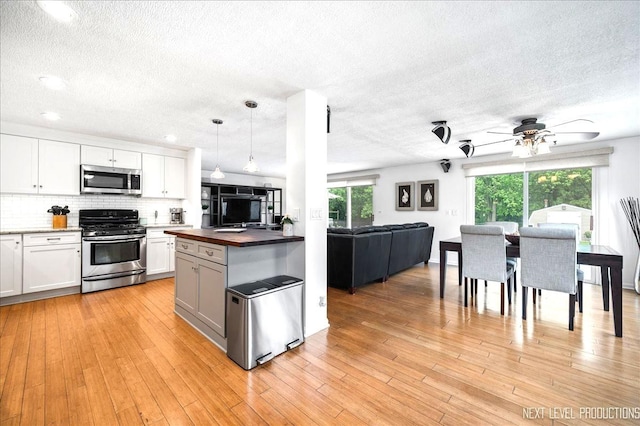 636 Cambridge Dr, Schaumburg, IL 60193 - kitchen with appliances with stainless steel finishes, open floor plan, a textured ceiling, ceiling fan, and backsplash