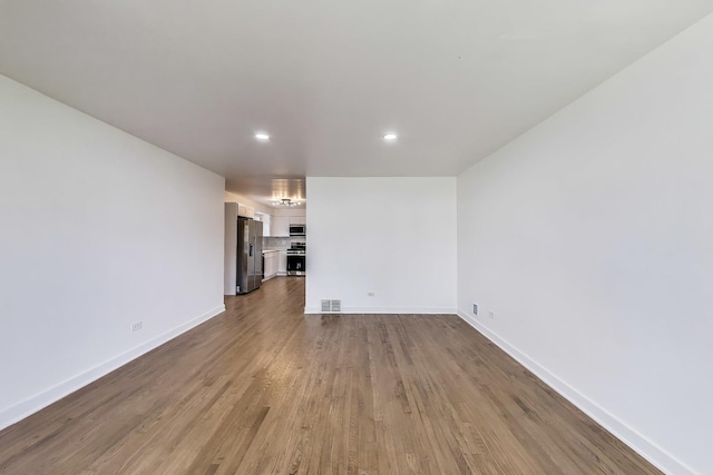 839 N Kildare Ave, Chicago, IL 60651 - unfurnished living room featuring baseboards, recessed lighting, and dark wood-style floors