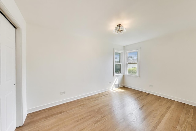 839 N Kildare Ave, Chicago, IL 60651 - spare room with light wood finished floors, baseboards, and a chandelier