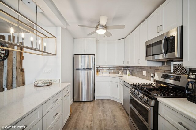 400 E Randolph St Unit 826, Chicago, IL 60601 - kitchen with appliances with stainless steel finishes, backsplash, ceiling fan, and light wood-type flooring