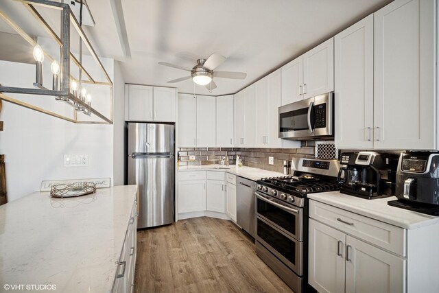 400 E Randolph St Unit 826, Chicago, IL 60601 - kitchen with appliances with stainless steel finishes, a ceiling fan, light wood-style flooring, tasteful backsplash, and white cabinetry