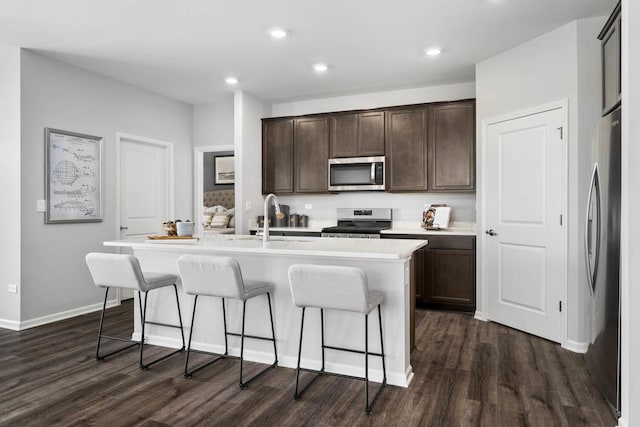 14712 S Azalia Cir, Plainfield, IL 60544 - kitchen with appliances with stainless steel finishes, dark wood-style flooring, a center island with sink, a kitchen breakfast bar, and recessed lighting